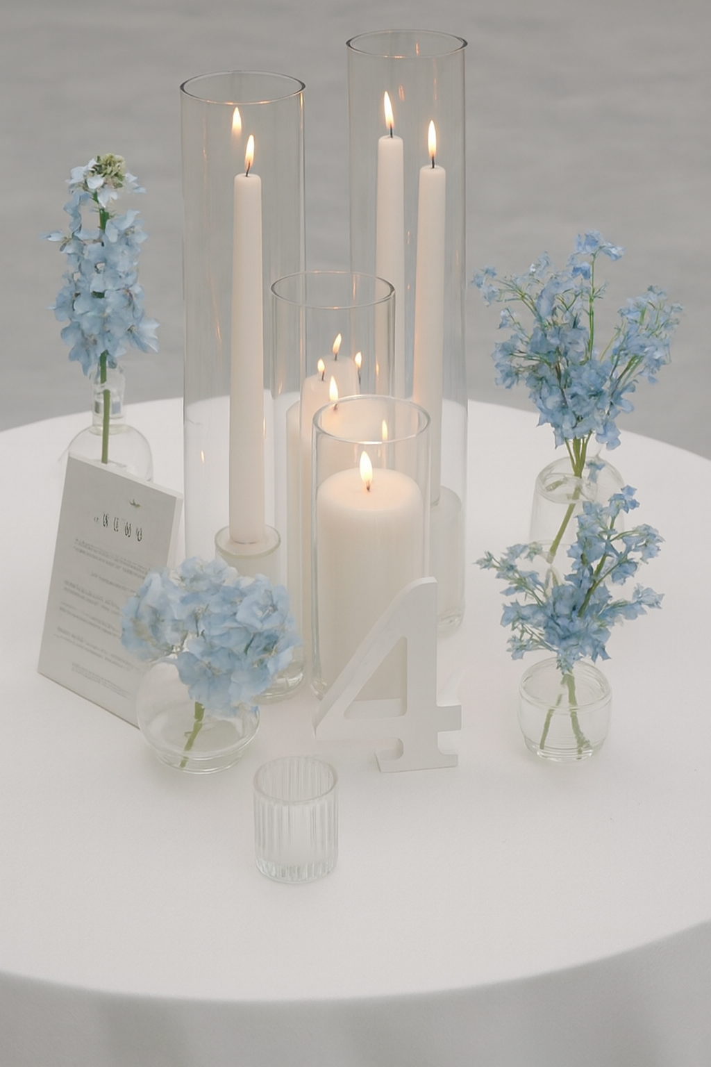 White pillar candles in glass holders styled on an elegant wedding table setting