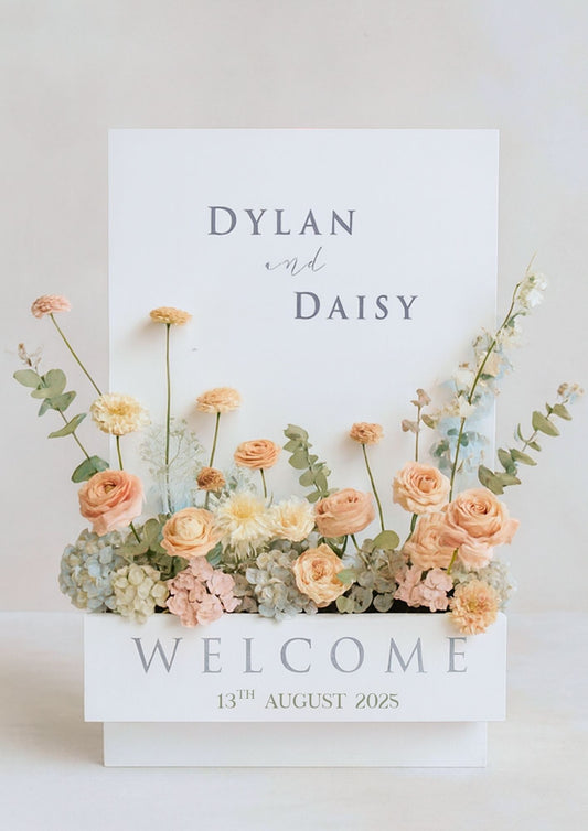 Floral arrangement in a box and welcome message.