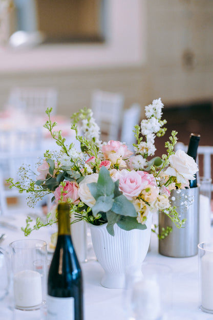 Floral arrangement in a vase with pink and white flowers on a table