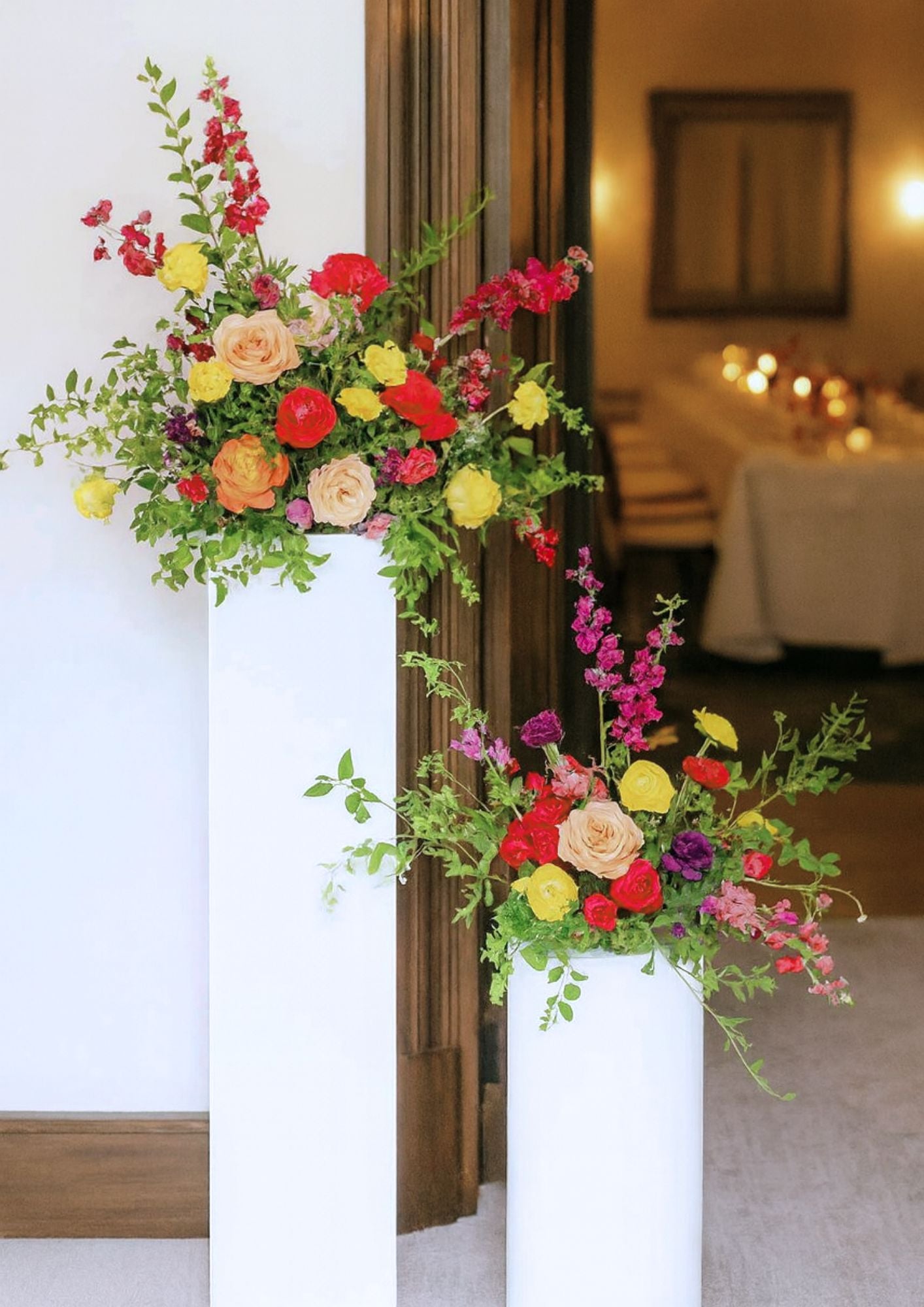 Colourful flowers arranged on a pedestal to welcome guests at an intimate dinner