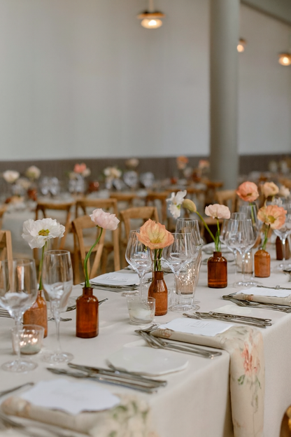 Wedding table styled with bud vases and pillar candles.