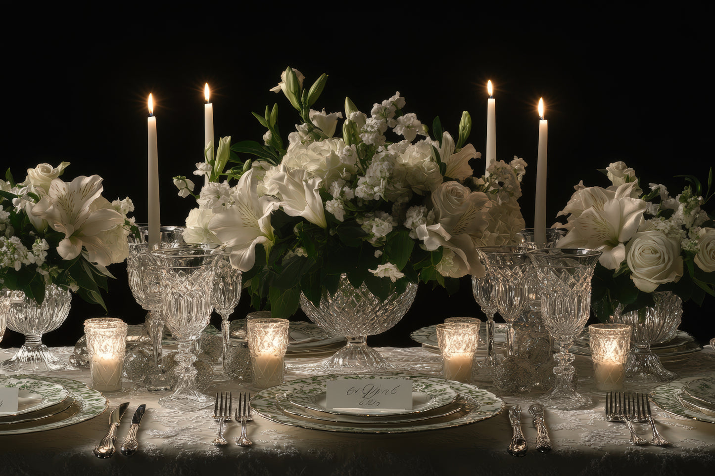 Elegant table setting with crystal glasses, invory candles, and medium size floral arrangements.