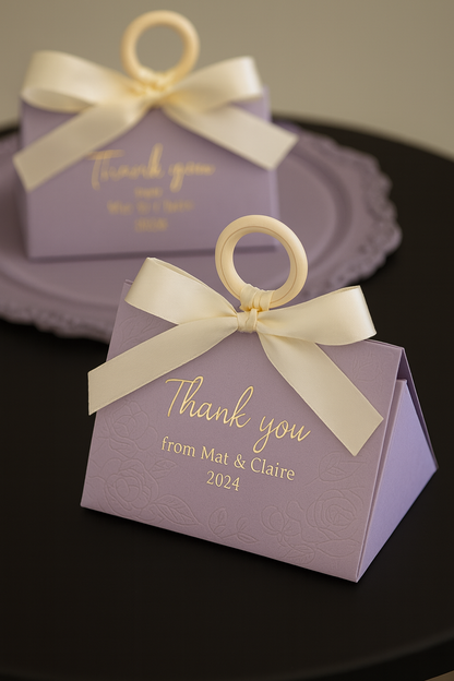 Purple favor boxes with white ribbons and 'Thank you' text.